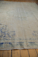 Distressed vintage Oushak carpet with worn pile, visible knot heads, and short fringe.