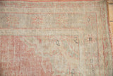 Distressed vintage Oushak carpet pile with faded rose, ivory hues and visible wear.