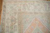 Soft wool pile of the distressed Oushak rug, showing even wear and faded geometric patterns.
