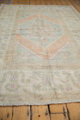 Distressed Oushak rug close-up with soft wool pile, even wear, and ivory, seafoam, terra cotta.