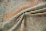 Soft wool pile with even wear, faded seafoam, terra cotta, and ivory tones.