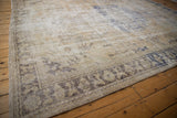 Distressed Oushak carpet corner with faded floral arabesque main border and fringed end.