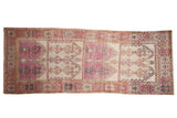 Vintage distressed Oushak runner with stacked geometric panels in faded aubergine, ivory, and charcoal.