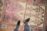 Overhead view of a distressed Oushak runner's stacked panels in inverted aubergine and ivory.