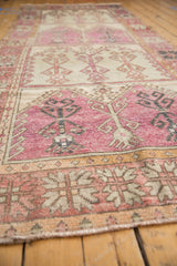 Angled view of a distressed Oushak runner showing its stacked geometric panels and low-pile texture.