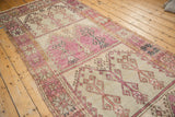 Distressed texture and geometric palmette border in aubergine, ivory, and saffron yellow.