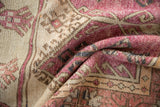A folded vintage Oushak runner showing the nubby texture of its mostly even wear.