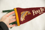 Felt pennant's green ties and yellow left edge, held by a hand.