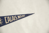 Pointed tip of the dark blue felt Calais, Maine pennant, showing white 'MAINE' letters.
