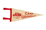 Vintage Camp Grindley felt flag with red cabin, trees, lake, and canoe graphic on white.