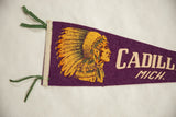 Close-up of vintage Cadillac felt pennant, showing green ties and partial chief graphic.