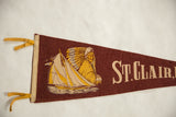 Graphic detail of a sailboat and Native American chief on the maroon felt St. Clair pennant.