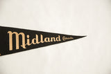 Tan script lettering on the tapering black felt tip of the vintage Canada pennant.
