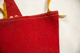 Close-up of the double-stitched seam and texture of the red vintage felt flag.