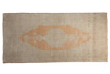 Distressed Oushak rug runner with a pale orange medallion and even wear on a neutral antique ivory field.
