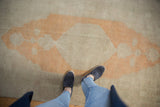 Mostly even wear across the soft, low pile of a distressed Oushak rug runner.