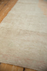 Mostly even wear across the low, hand-knotted pile of a distressed Turkish Oushak runner.