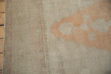 The soft, worn texture and intact side selvage of a distressed vintage Oushak rug runner.