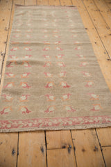 Distressed pile texture on vintage Oushak runner with raspberry floral pattern and vine-bud border.
