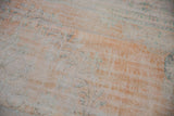 Worn apricot and ivory pile texture of the vintage Oushak rug with subtle blue motifs.