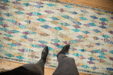 Distressed vintage Tulu runner with feet, featuring playful diamond patterns and faded colors.