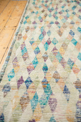 Distressed Tulu rug texture, showing worn pile with colorful diamond patterns.