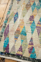 Textured distressed Tulu rug detail with colorful diamond patterns.