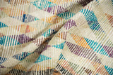 Textural detail of distressed Tulu rug, showing ivory, turquoise, aubergine, and orange stripes.
