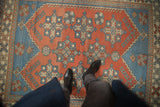 Distressed vintage Melas rug with cherry red and sky blue geometric patterns, showing even wear.