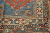 Distressed Melas carpet's corner reveals reciprocating pawn border and starburst motifs.