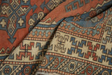 Stepped geometric patterns on vintage Melas carpet in brick red, sky blue, and ivory.