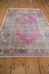 Vibrant magenta pile and purple stepped medallion on a distressed vintage Oushak rug.