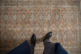 Distressed Oushak rug's geometric gul motifs in dusty rust, oxidized silver, and ivory.
