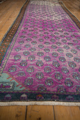 Distressed Oushak runner with vibrant magenta field and pale mint germinating plant motifs.