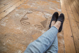 Vintage distressed Oushak runner showing worn pile, faded gold, ivory, and charcoal rams horn guls.