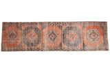 Vintage distressed Oushak runner with repeating terra cotta and charcoal medallions, 3'6