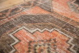Distressed Oushak runner texture with soft terra cotta, charcoal, and stepped geometric motifs.