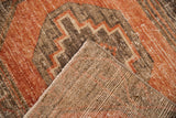 Textured distressed Oushak rug pile in dusty terra cotta and charcoal, showing woven foundation.