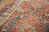 Vintage distressed Oushak runner's brick red, charcoal, beige pinwheel motif and worn texture.