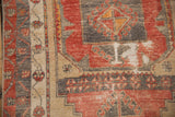 Distressed Oushak rug runner's secured side and geometric patterns in brick red, charcoal, sand.
