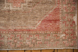 Oushak rug close-up showing foundation through worn dusty blush red and ivory pile.