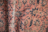 Distressed Sparta rug texture revealing faded blush, cobalt floral patterns, and abrashes.