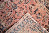 Distressed floral pattern and folded border of a vintage Turkish Sparta runner.