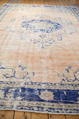 Distressed cobalt blue and beige Oushak border showing wear and fringe.