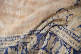 Decorative distressed Oushak carpet texture, showcasing abrashed beige pile and cobalt blue motif.