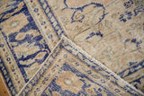 Distressed pile texture of vintage Oushak rug showing faded cobalt blue and beige patterns.