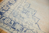 Decorative distressed cobalt blue patterns revealing worn texture on ivory Oushak.