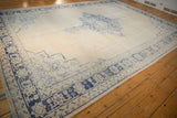 Faded cobalt blue border pattern and distressed ivory texture on vintage Oushak rug.