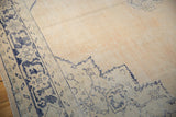 Vintage distressed Oushak rug with worn pile, faded cobalt blue pattern, and abrashed ivory field.