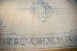 Distressed cobalt blue geometric border on an abrashed ivory field of a vintage Oushak rug.